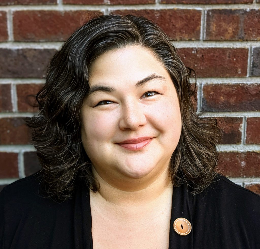 Headshot of Hough Law owner Nicole "Nikki" Hough with a brick wall as a background.